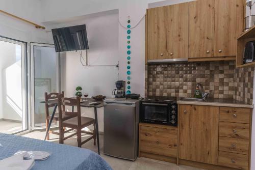 uma cozinha com um micro-ondas e uma mesa com cadeiras em Ioannis Rooms Δωμάτια με θεα στη θαλασσα em Paránimfoi