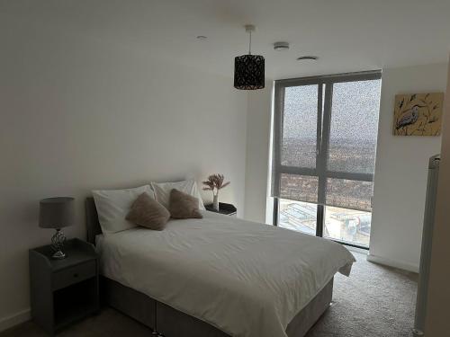a bedroom with a bed and a large window at Immaculate 2-Bed Apartment in east London in London