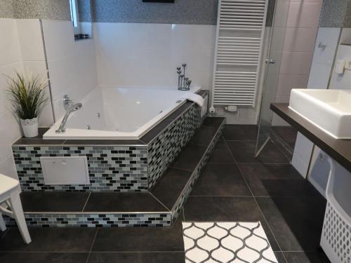 a bathroom with a tub and a sink at Holiday Home Sternenhimmel by Interhome in Schwanau