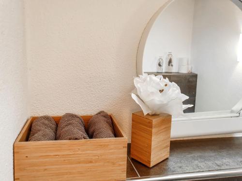 a wooden box of towels sitting on a table in front of a mirror at Holiday Home Sternenhimmel by Interhome in Schwanau