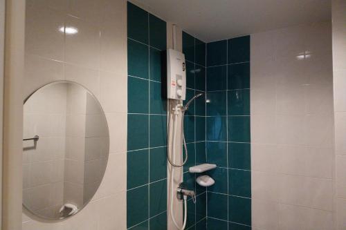 uma casa de banho com um chuveiro e um espelho redondo em Sleep Hotel em Chon Buri