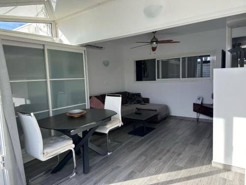 un salon avec une table et des chaises noires dans l'établissement Village naturiste - Villa Port-Nature 1 - Le Tantra, au Cap d'Agde