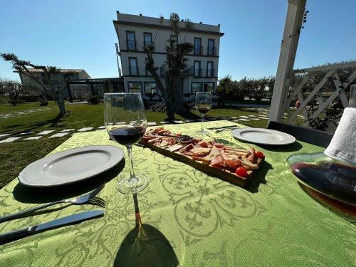 a table with two glasses of wine and a tray of food at Evergreen Laguna Vain-Lezhe in Lezhë