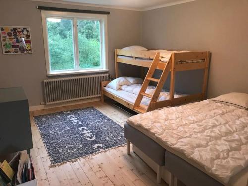 a bedroom with two bunk beds and a window at Edänge 61 in Ljusdal