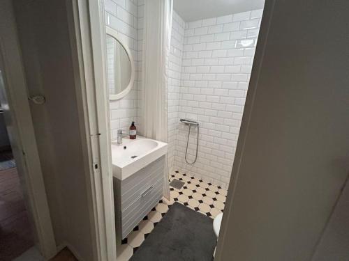 a white bathroom with a sink and a mirror at Edänge 61 in Ljusdal