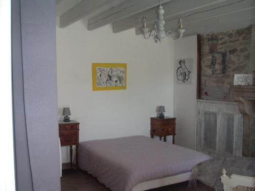 a bedroom with a bed and two night stands at Chambre d'hôte du Plessis in Beaurepaire