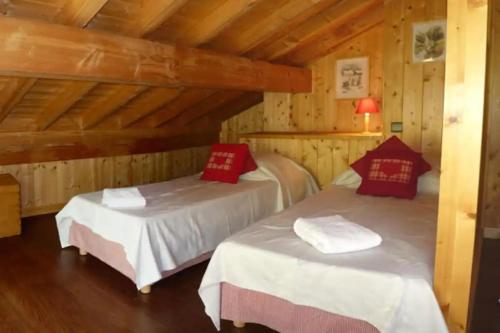 Dos camas en una habitación con paredes de madera. en 9-Bed Chalet with Easy Access to Avoriaz 1800, en Morzine