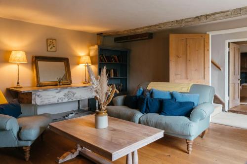 a living room with blue couches and a table at Retreat East in Ipswich