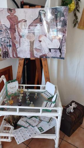 a table with a painting on a wall next to a desk at Au Plais De Langebaan at Palm Tree Villa in Langebaan
