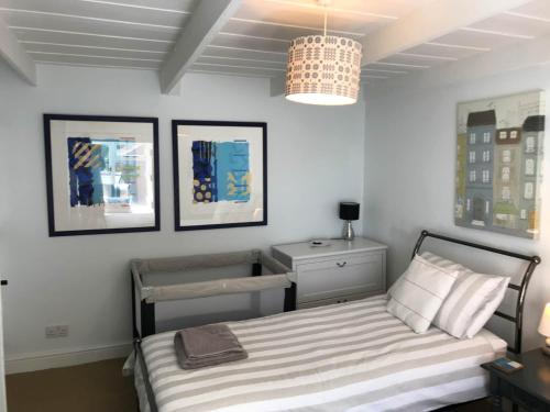 a bedroom with a bed and a chandelier at Cilrhiw, Seaside Stone Cottage in Llangrannog in Llangrannog