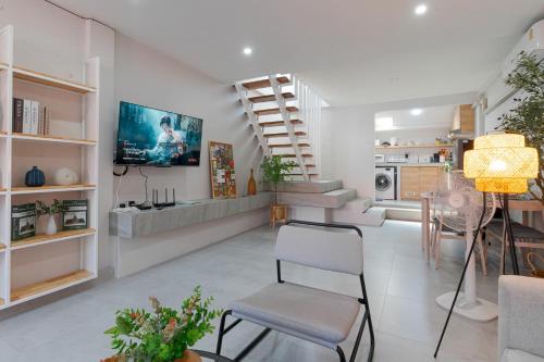 a living room with a staircase and a dining room at Modern Style Townhome /2BR near CNX moat in Chiang Mai