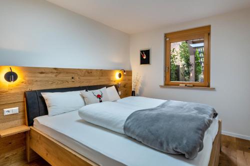 a bedroom with a large white bed and a window at Ferienwohnung Heimatschön in Münstertal