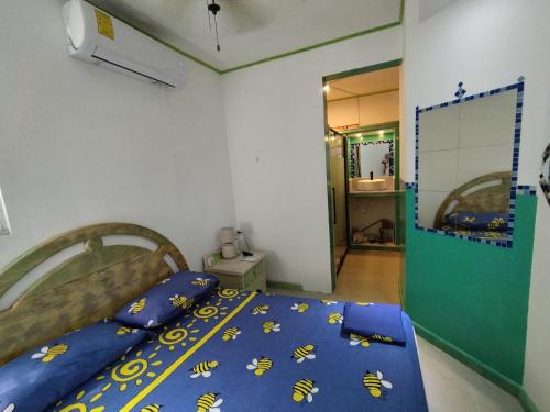 Un dormitorio con una cama con una manta azul con abejas. en Private Rooms-Art Punta Cana, en Punta Cana