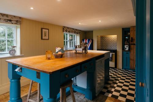 a kitchen with a blue island with a wooden counter top at Retreat East in Ipswich
