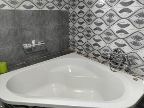 a white sink in a bathroom with a tile wall at Luckyone Hotel in Lilongwe