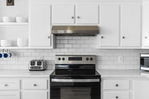 a kitchen with a black stove and white cabinets at Genuine Holden Beach Ocean front with private pool and great beach views in Holden Beach