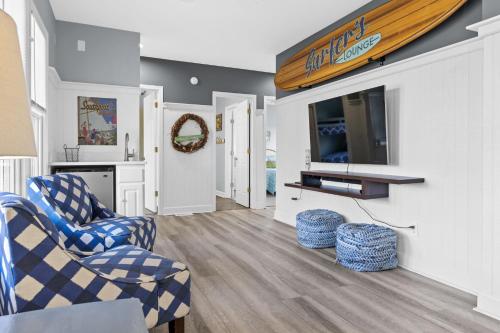 a living room with two chairs and a tv at Genuine Holden Beach Ocean front with private pool and great beach views in Holden Beach