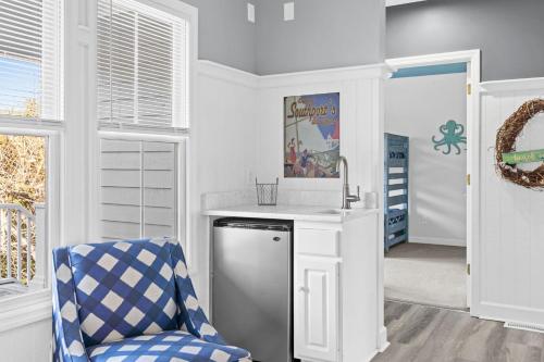 a kitchen with a sink and a chair in a room at Genuine Holden Beach Ocean front with private pool and great beach views in Holden Beach