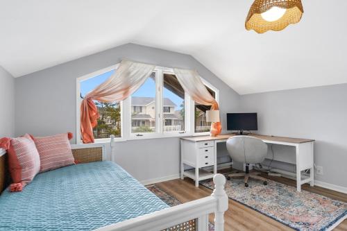 a bedroom with a bed and a desk and a window at Isle Of A Time Brunswick Vacation Rentals Canal front with Boat slip in Ocean Isle Beach