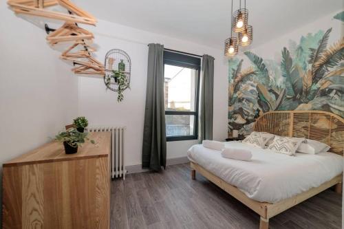 a bedroom with a bed with a tropical mural on the wall at VILLE ET VOLCANS - Maison 9 couchages avec garage et extérieur in Clermont-Ferrand