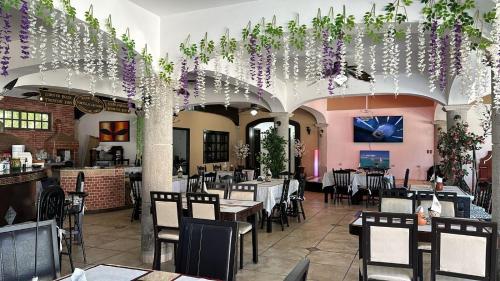 a restaurant with tables and chairs and purple flowers at Hacienda Cúpulas Blue Private Residence Club in Cozumel