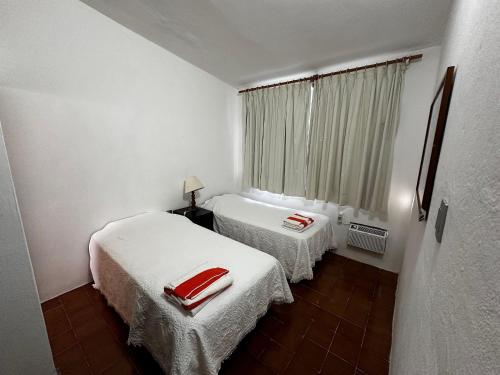 a small room with two beds and a window at Experiencia en la playa para 16 personas in Puerto Arista