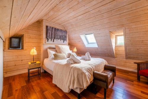 Cette chambre en bois comprend un grand lit. dans l'établissement KasaLilou, Grand Gîte de prestige St Lary, à Vignec