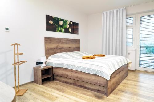 een slaapkamer met een bed met een houten hoofdeinde bij Lanškroun apartmány v centru in Lanškroun
