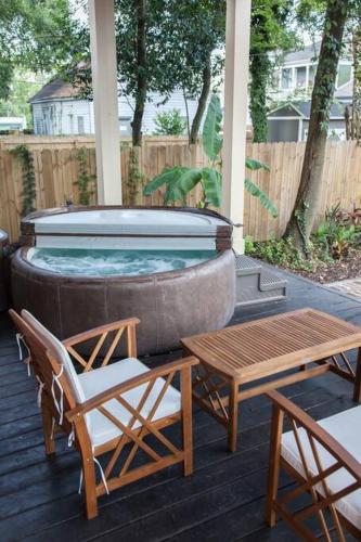 a hot tub on a deck with a table and chairs at Secret Garden Studio w/ Hot Tub: Near Forsyth Park in Savannah