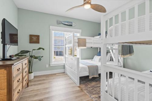 a bedroom with two bunk beds and a television at Havana in Ocean Isle Beach