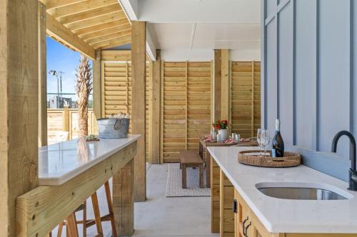a kitchen with wooden walls and a counter with a sink at Havana in Ocean Isle Beach