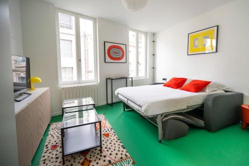 une chambre avec un lit, une table et une télévision dans l'établissement Alma, au Havre