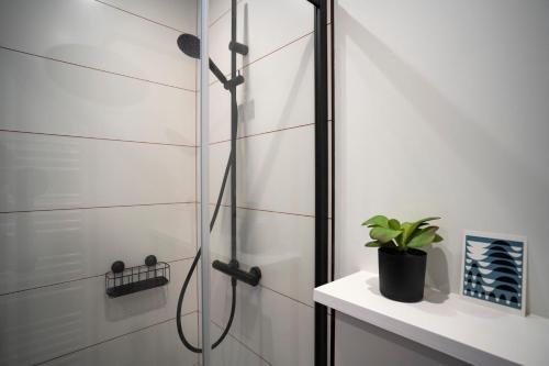 une douche avec une porte vitrée dans une salle de bain dans l'établissement Alma, au Havre