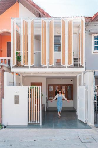a woman walking into the front of a house at Modern Style Townhome /2BR near CNX moat in Chiang Mai
