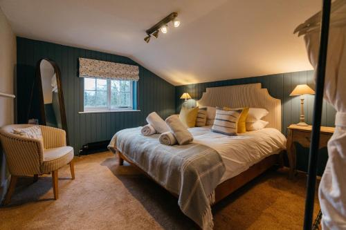 a bedroom with a bed and a chair and a window at Retreat East in Ipswich