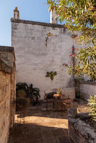 a patio with a table and chairs in front of a wall at Masseria Brigantino in Torre Canne
