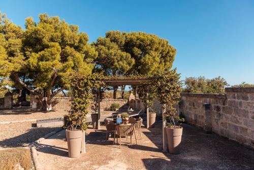 a garden with trees and a table and chairs at Masseria Brigantino in Torre Canne