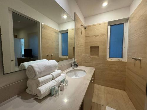 a bathroom with a sink and a mirror and towels at La mejor ubicación en Playa! in Playa del Carmen
