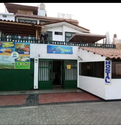 Edificio blanco y verde con balcón en Julia's House huanchaco, en Trujillo