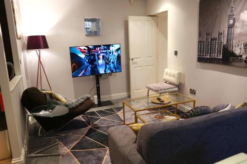 een woonkamer met een bank en een flatscreen-tv bij Home In Birmingham New Street in Birmingham