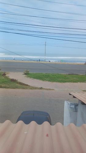 a view of a beach with a picnic table and a road at Julia's House huanchaco in Trujillo