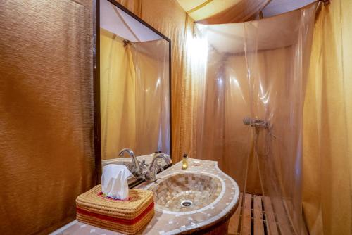 a bathroom with a sink and a large mirror at Erg Chegaga Desert Luxury Camp in El Gouera