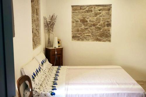 een slaapkamer met een bed en een stenen muur bij 2 bedrooms appartement with terrace at Finocchito in Finocchito