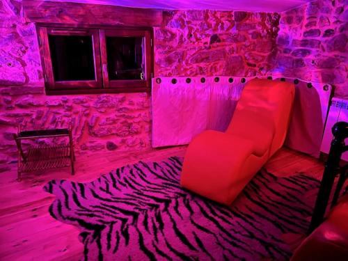 Cette chambre dispose d'un canapé rouge et d'un tapis zébré. dans l'établissement Love room de Blanche Neige, à Assignan