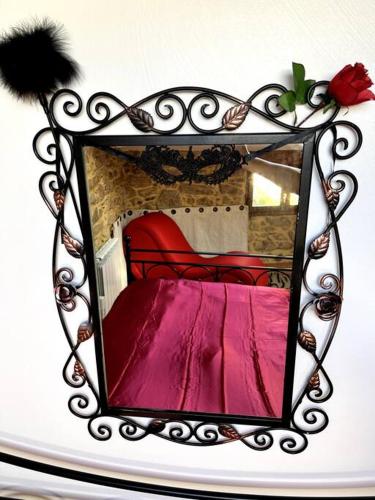 - un miroir avec un lit rouge dans l'établissement Love room de Blanche Neige, à Assignan