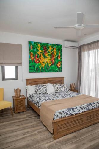 a bedroom with a bed and a painting on the wall at Entire Appartment - Pereybere, Grand Baie in Bain Boeuf