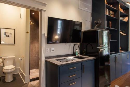 eine Küche mit einer Spüle und einem schwarzen Kühlschrank in der Unterkunft Intimate Library Studio - Minutes to Forsyth Park in Savannah