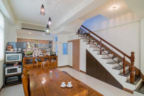 a living room with a wooden table and a staircase at Zhileju Homestay in Hualien City