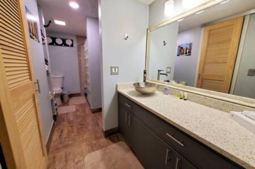 a bathroom with a sink and a large mirror at Atrium Condo Oceanview - Sleeps 4 Guests 107 in Cape Canaveral