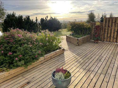 a wooden deck with some plants and flowers at Bjarkarlækur - Meet the Locals in Reykholt